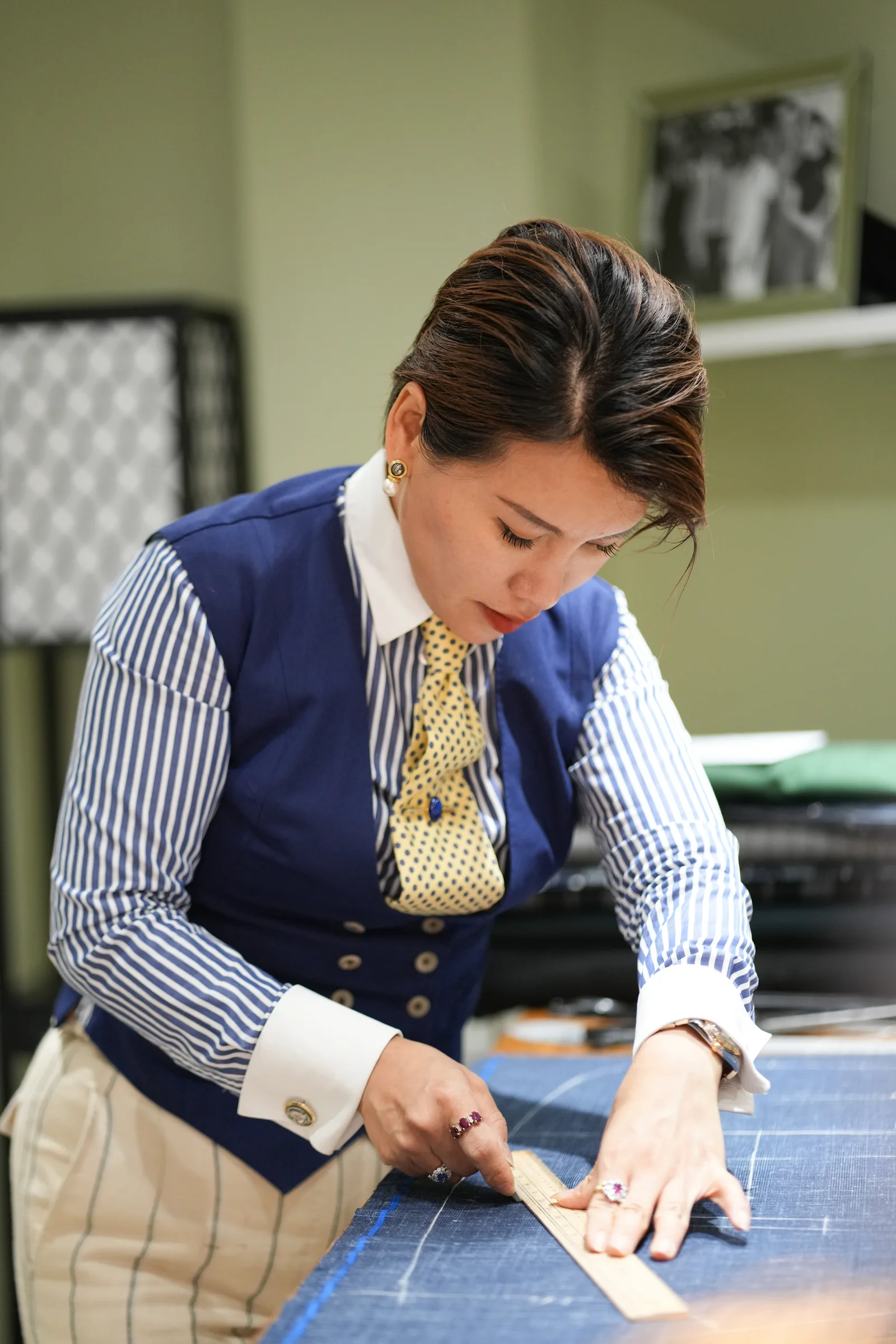Yingmei Quan drawing a chalk line across blue cloth marked with pattern lines