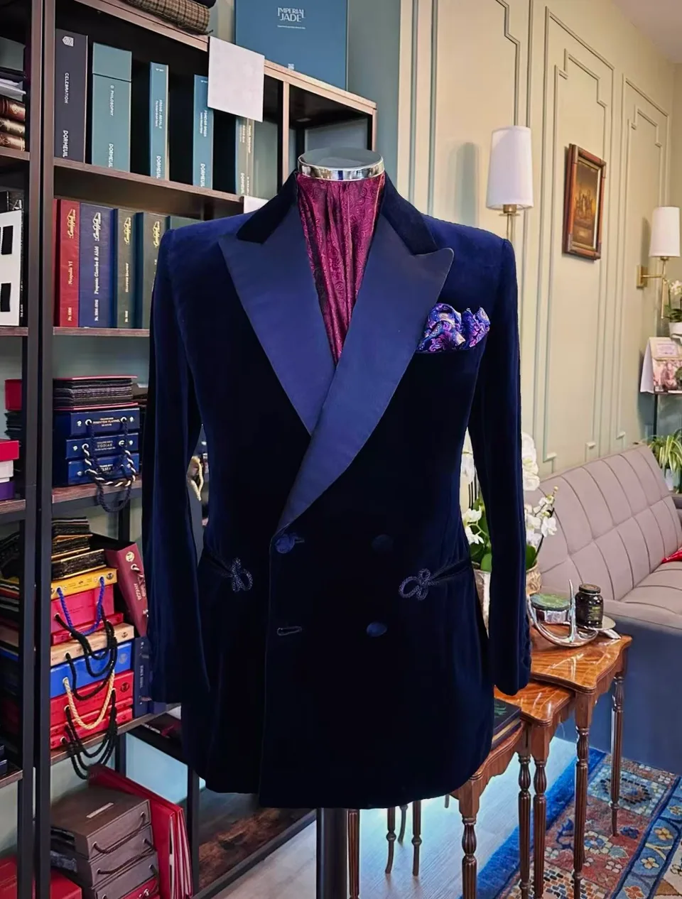 Full front view of a midnight velvet double-breasted evening jacket with frog closures on a tailor’s mannequin