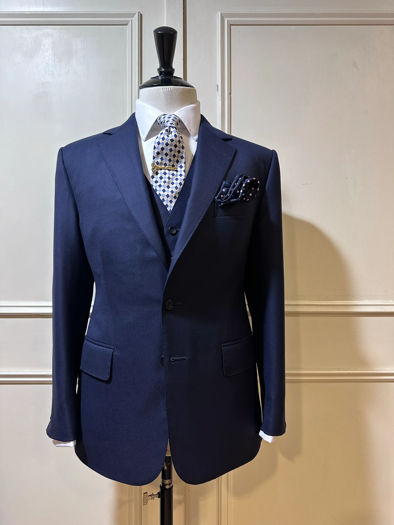 Mannequin view of a midnight-navy three-piece suit, with a two-button notch-lapel jacket and matching five-button waistcoat.