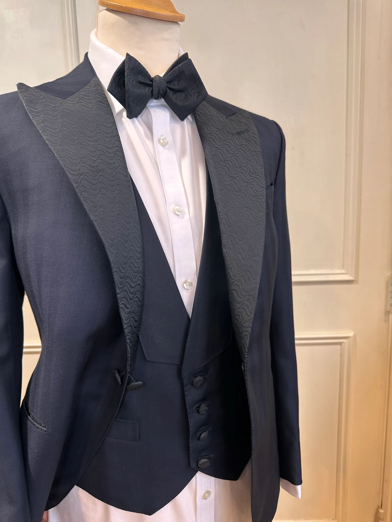 Three-piece view of the midnight jacquard peak-lapel tuxedo with a matching five-button evening waistcoat.