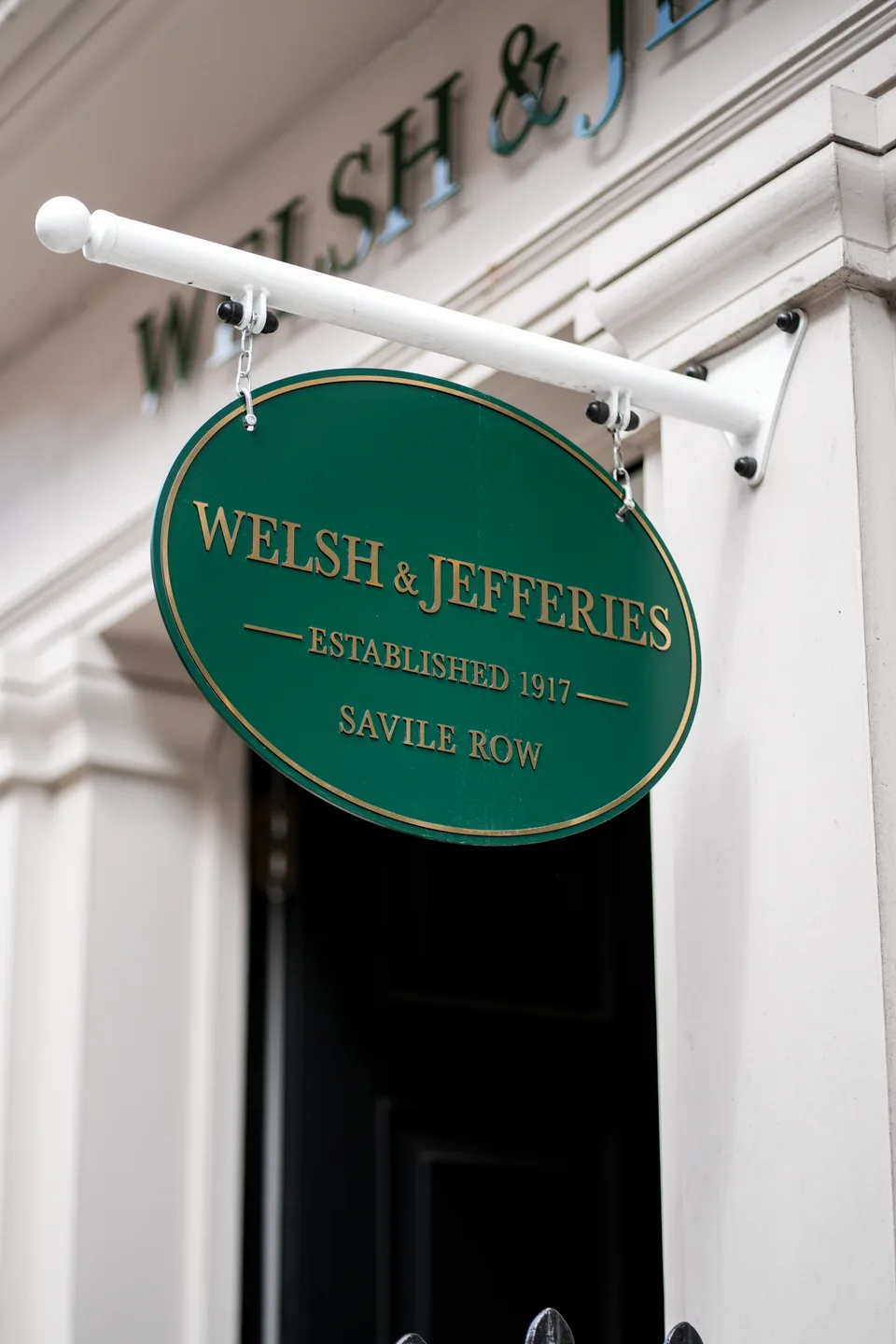 白色店门旁悬挂的 Welsh & Jefferies 椭圆店招