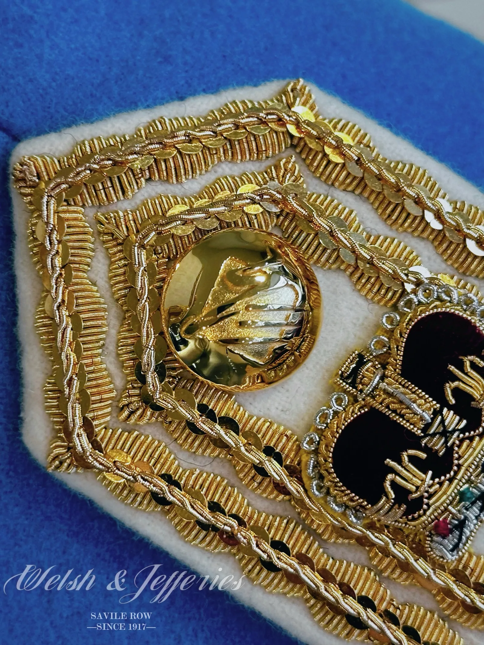 Gold bullion shoulder board on cerulean cloth with crown, star and wreath devices.