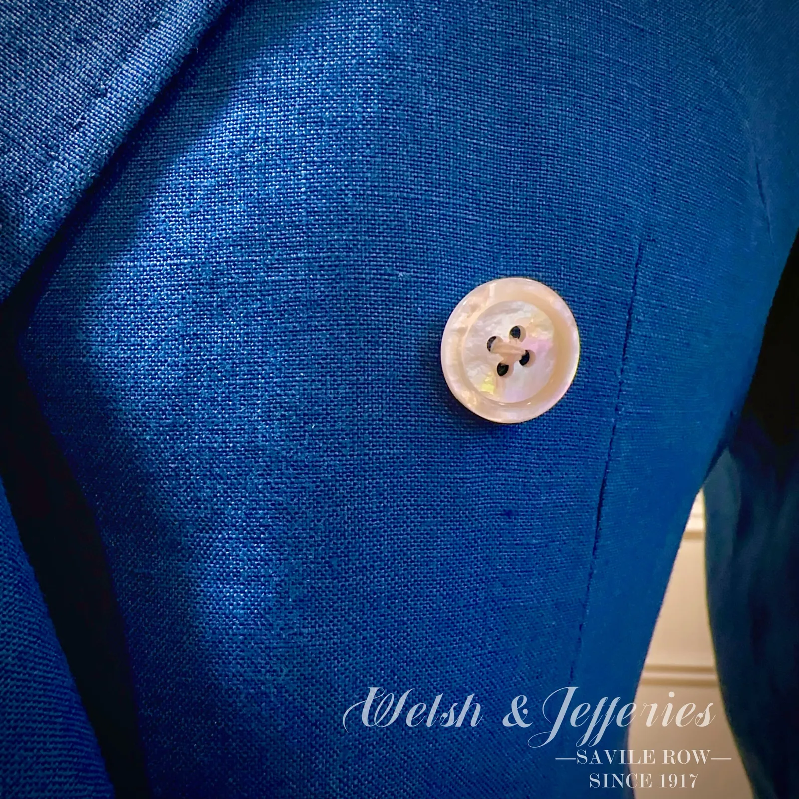 Button and front detail on electric-blue double-breasted ladies' three-piece suit.