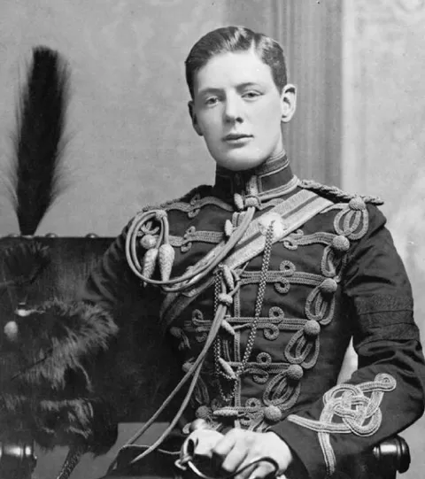 Young Winston Churchill seated in the braided uniform of the 4th Queen’s Own Hussars.