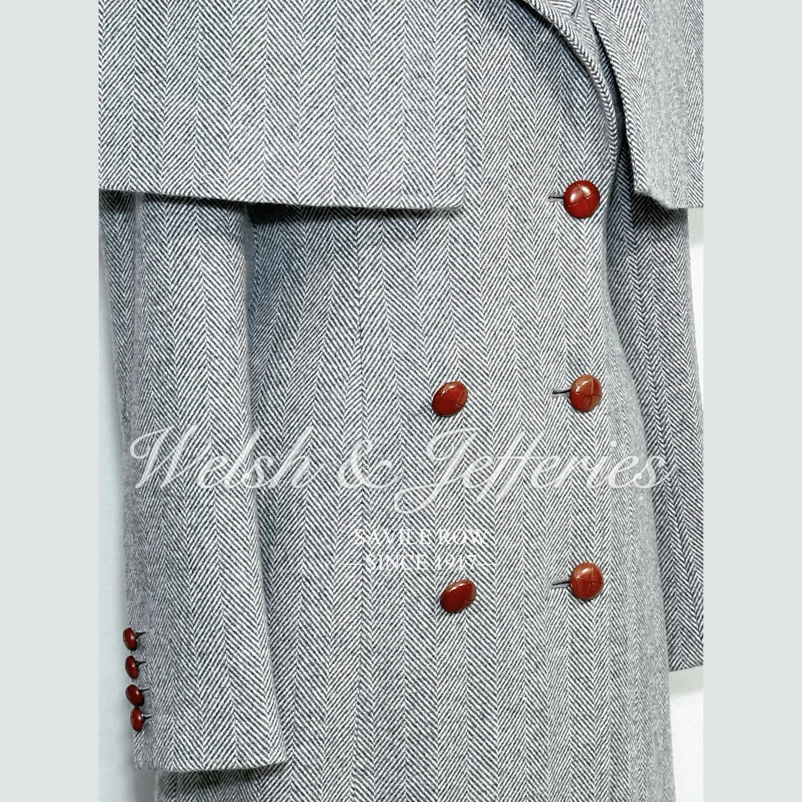 Button and front detail of the pale-grey herringbone cape overcoat.