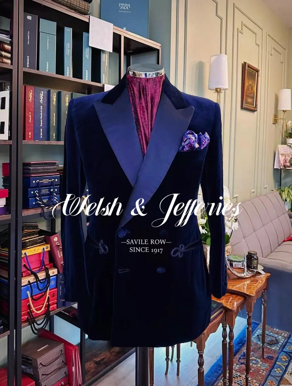 Full front view of a midnight velvet double-breasted evening jacket with frog closures on a tailor’s mannequin