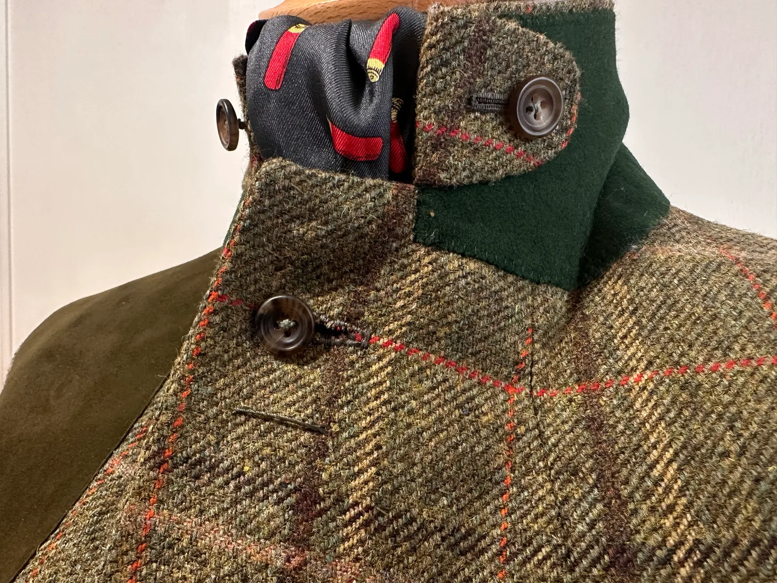 Convertible collar detail on the olive windowpane country three-piece suit, shown fastened at the throat.