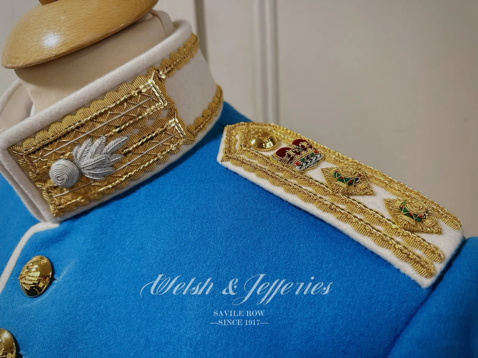 Ivory high collar and gold shoulder board bearing crown, star and wreath devices.