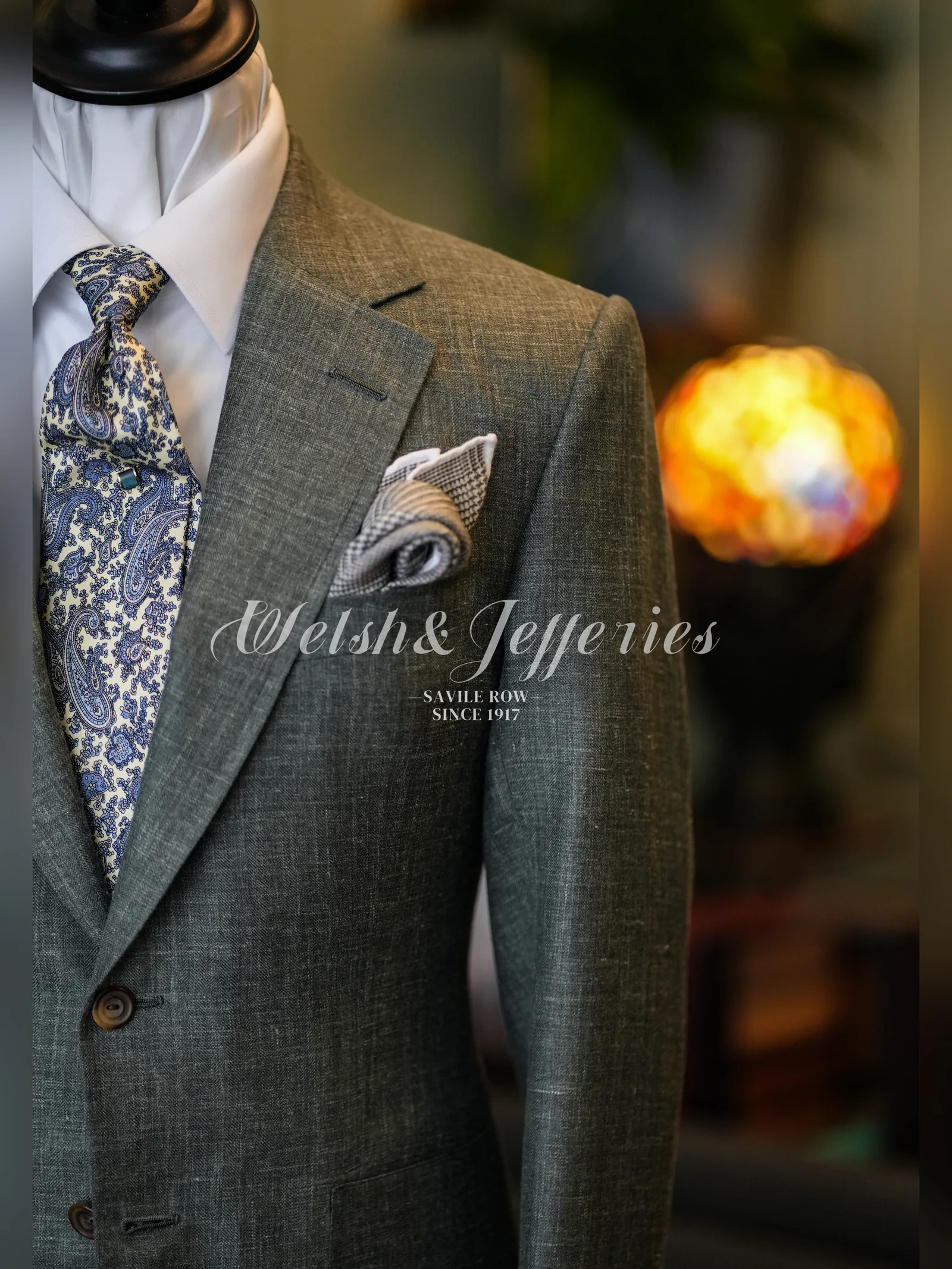 Close view of the lapel and breast pocket on a moss-grey crosshatch summer jacket