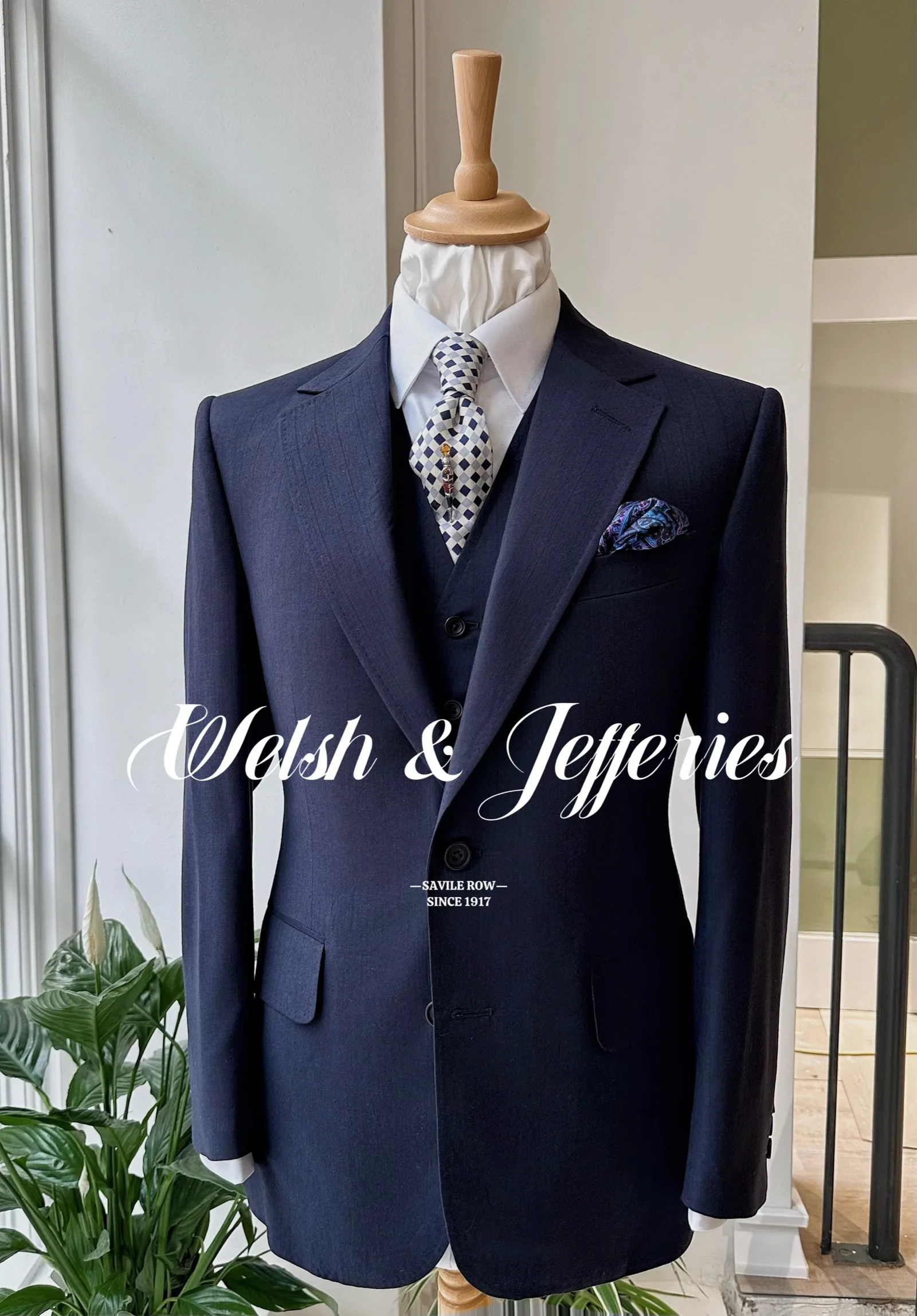 Full front view of a navy vicuña three-piece suit on a tailor’s mannequin