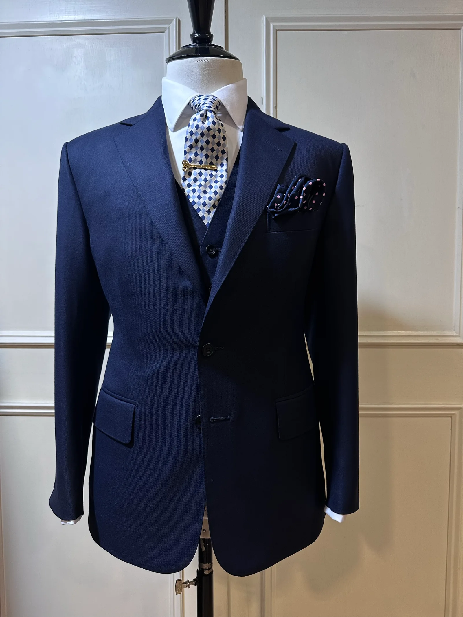 Mannequin view of a midnight-navy three-piece suit, with a two-button notch-lapel jacket and matching five-button waistcoat.