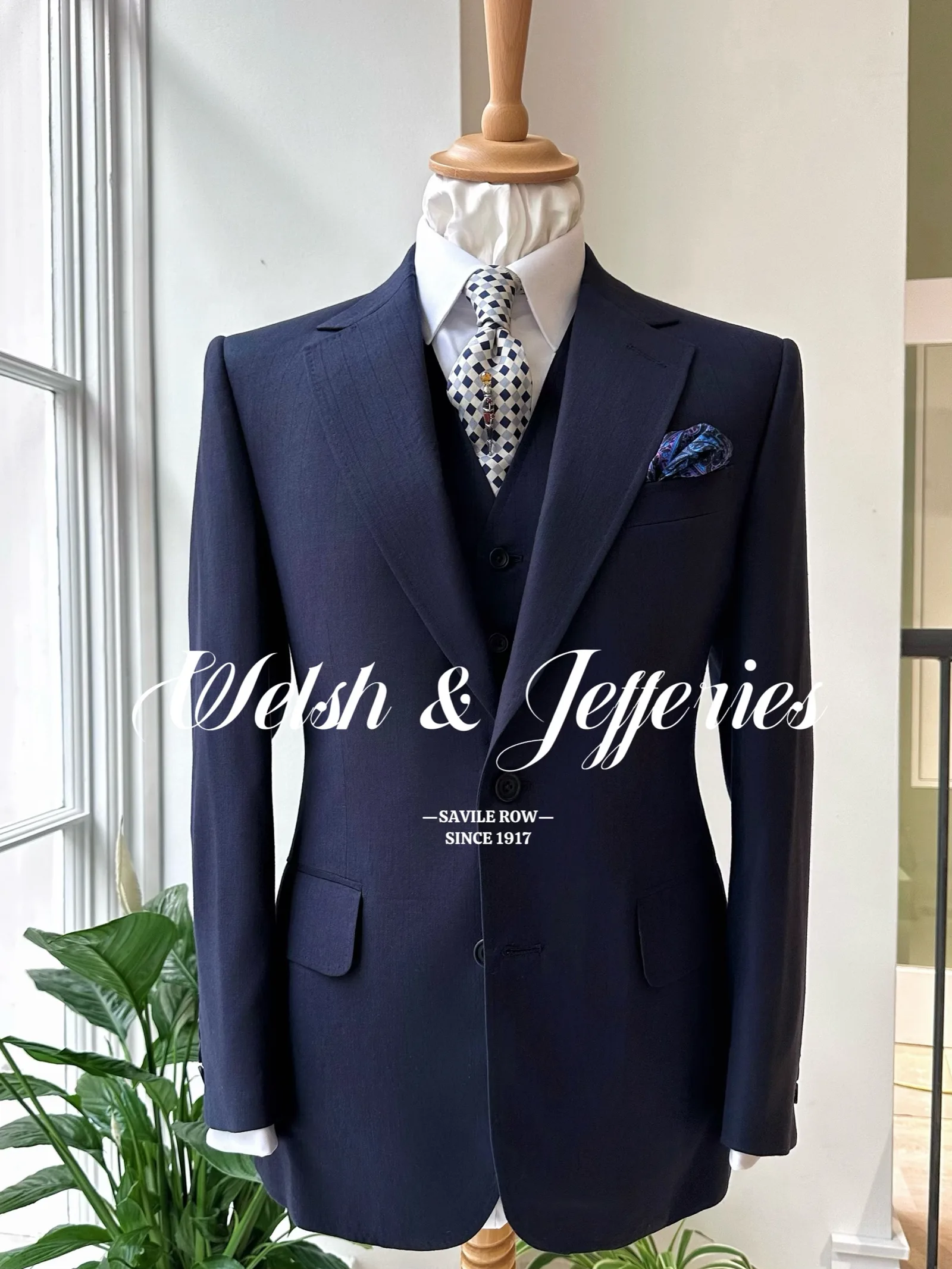 Alternate front view of a navy vicuña three-piece suit on a tailor’s mannequin