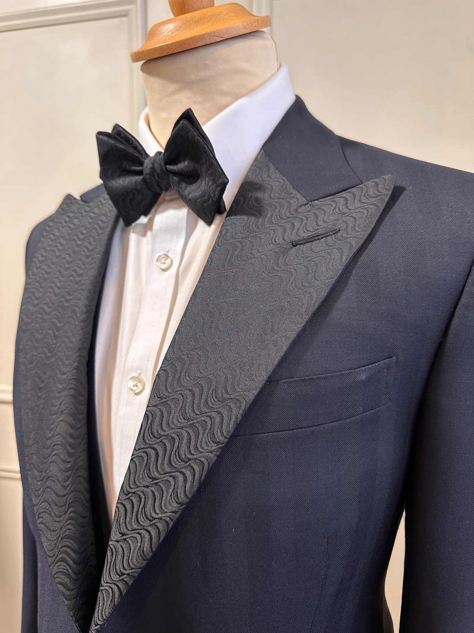 Close view of the tone-on-tone black jacquard peak lapel on the midnight jacquard peak-lapel tuxedo.
