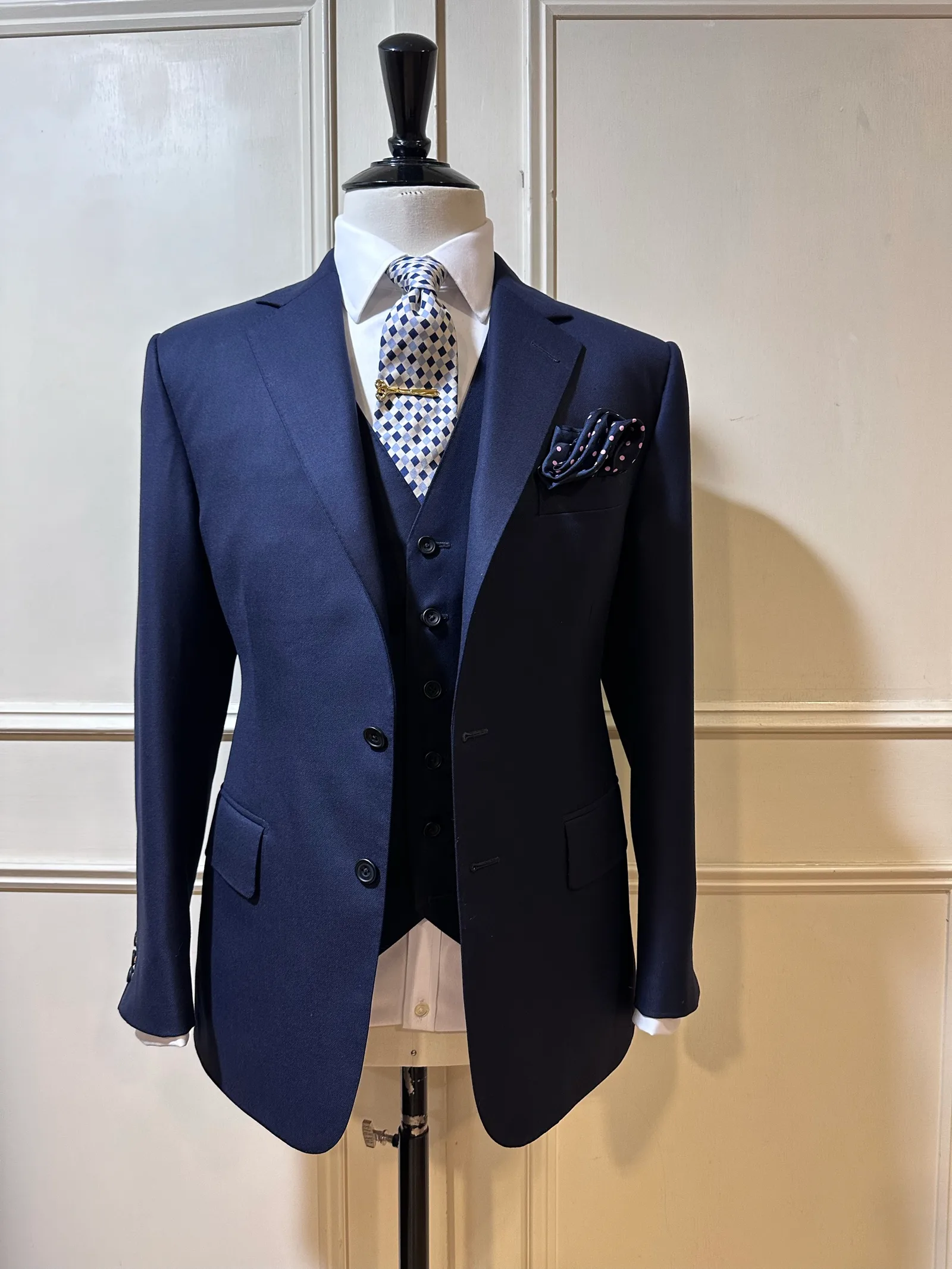 Mannequin view of a midnight-navy three-piece suit, with a two-button notch-lapel jacket and matching five-button waistcoat.