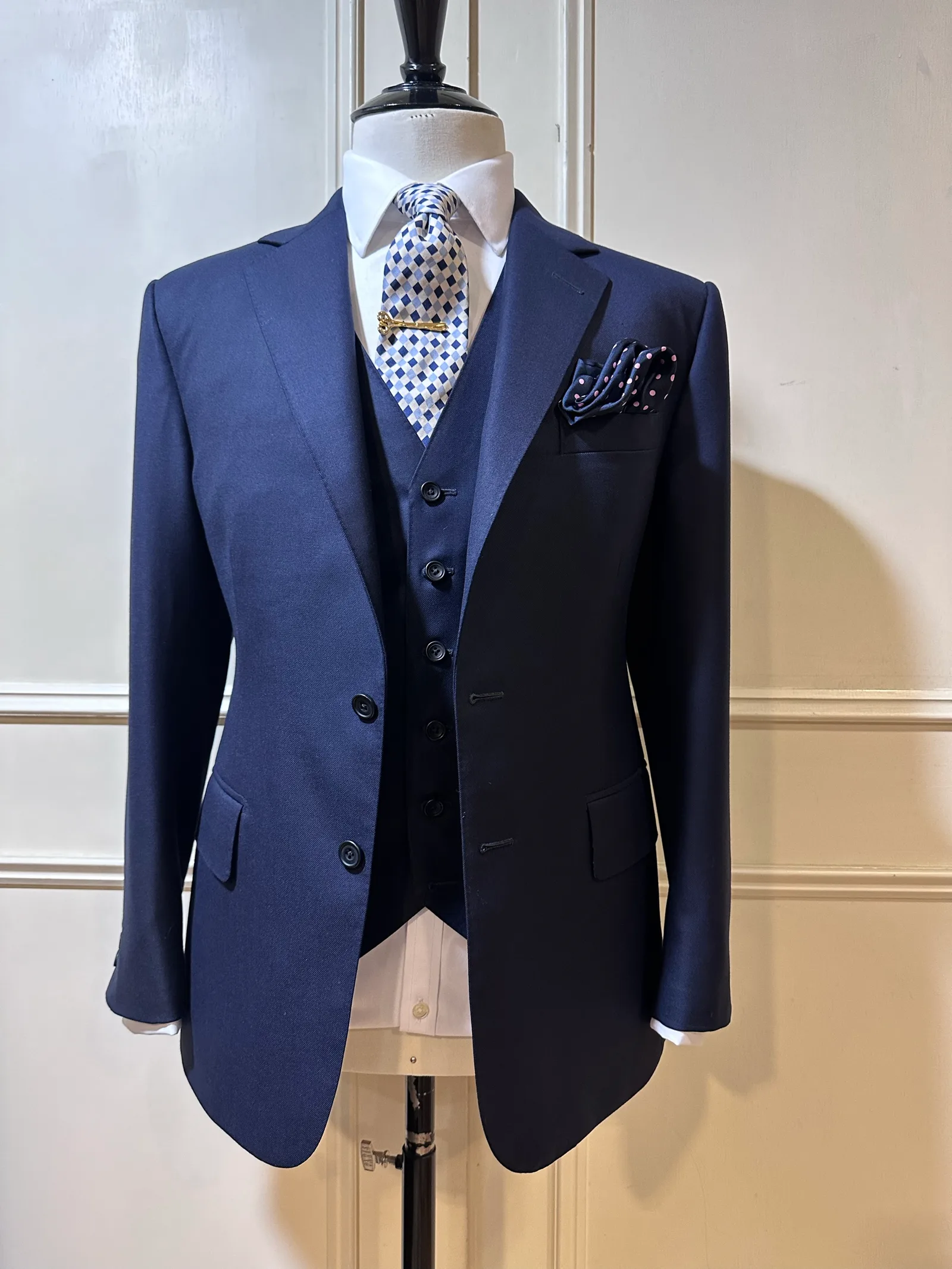 Mannequin view of a midnight-navy three-piece suit, with a two-button notch-lapel jacket and matching five-button waistcoat.