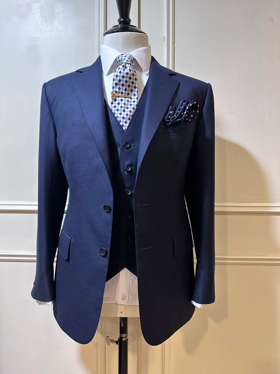 Mannequin view of a midnight-navy three-piece suit, with a two-button notch-lapel jacket and matching five-button waistcoat.
