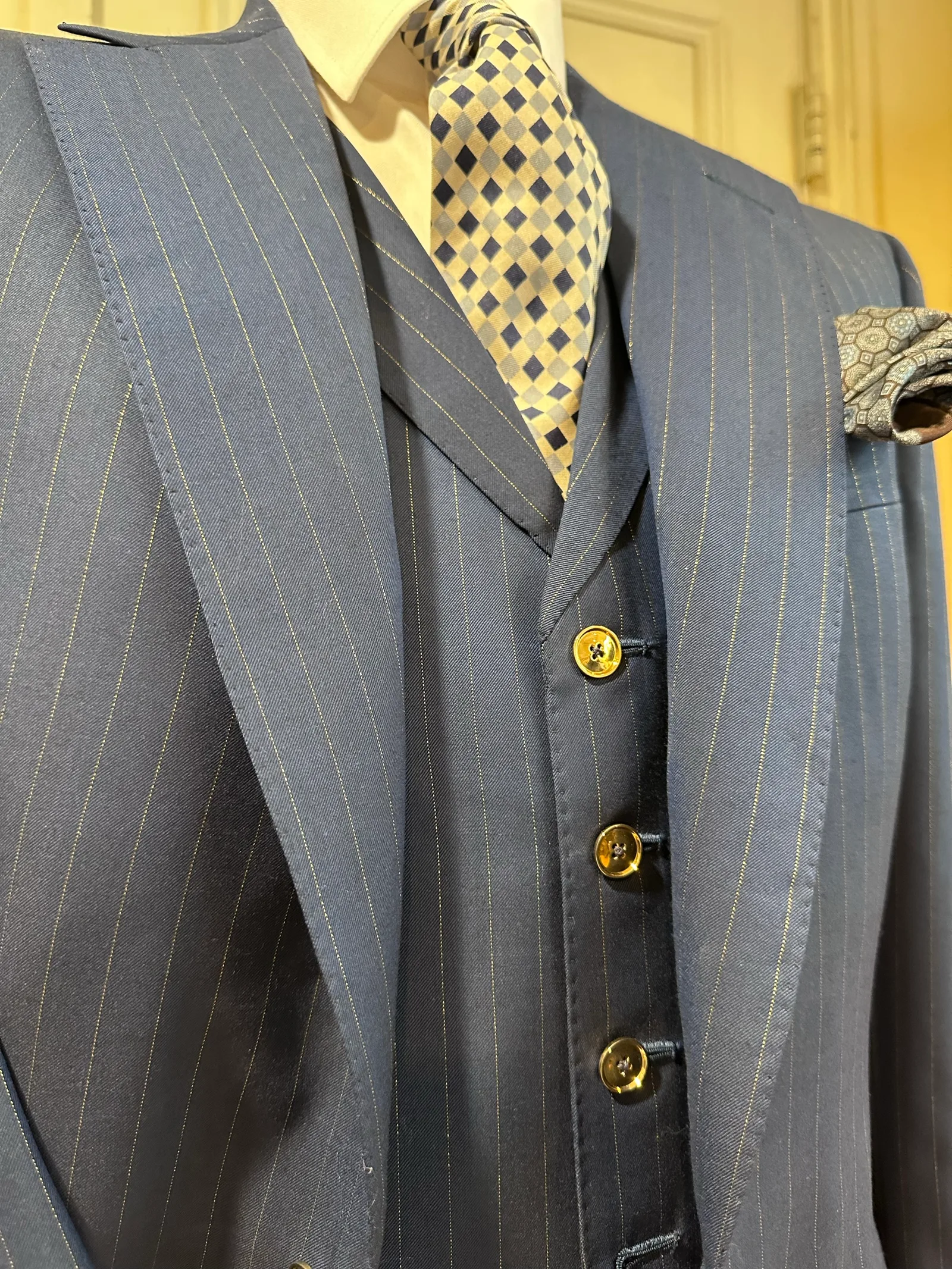 Close view of the royal blue chalkstripe three-piece suit with a matching five-button waistcoat with gilt buttons.