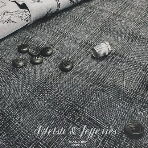 Close view of the cloth for charcoal Prince of Wales check cloth and tailoring components.