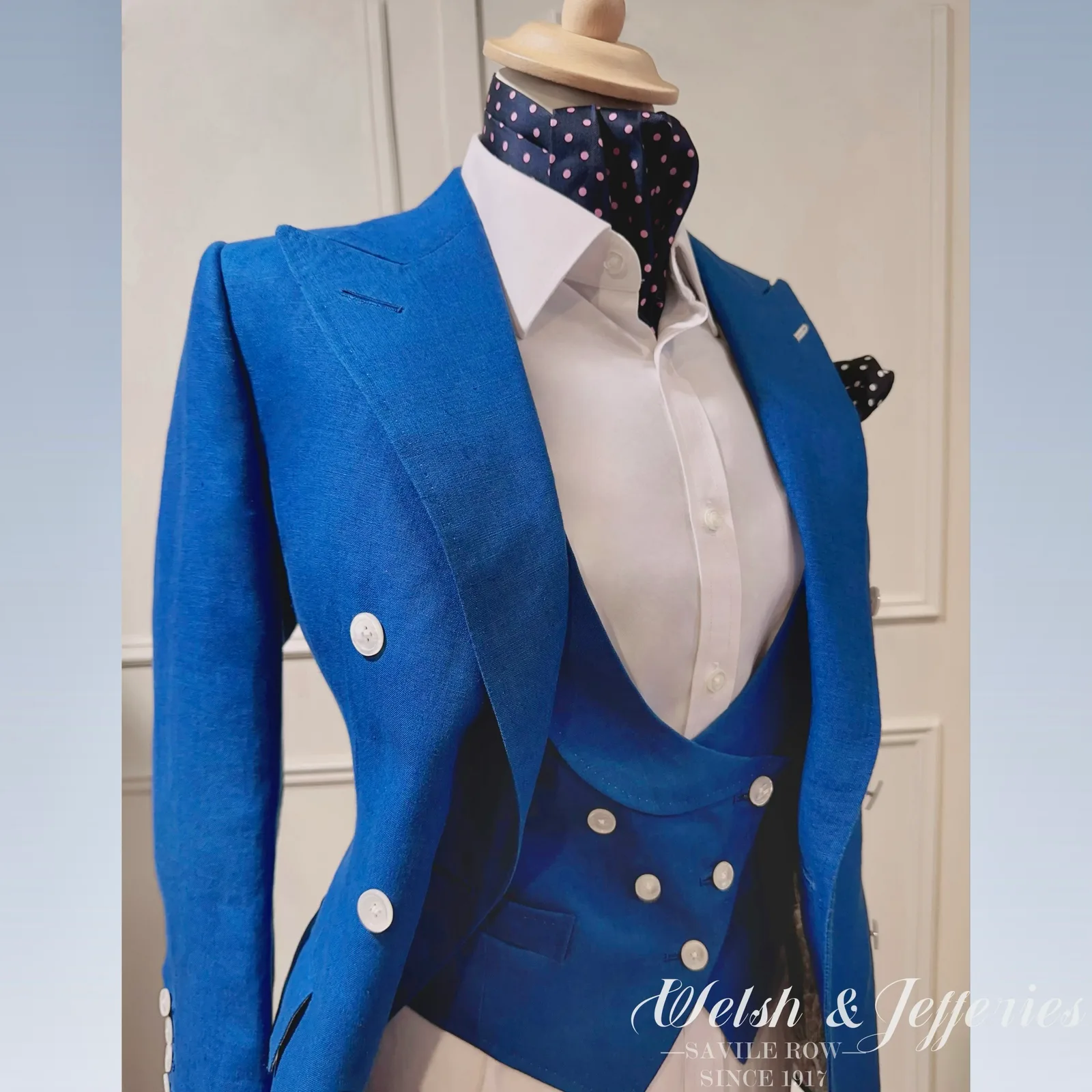 Close front view of electric-blue double-breasted ladies' three-piece suit.